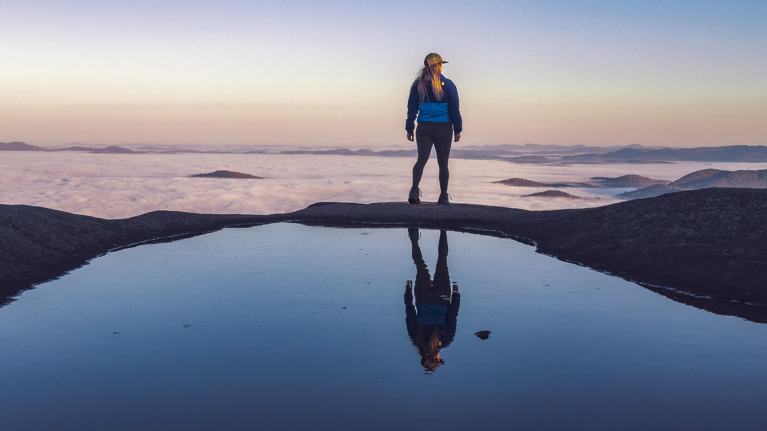 Janet Thomas Master and Elite Trainer on a summit above the clouds in the Adirondack Mountains