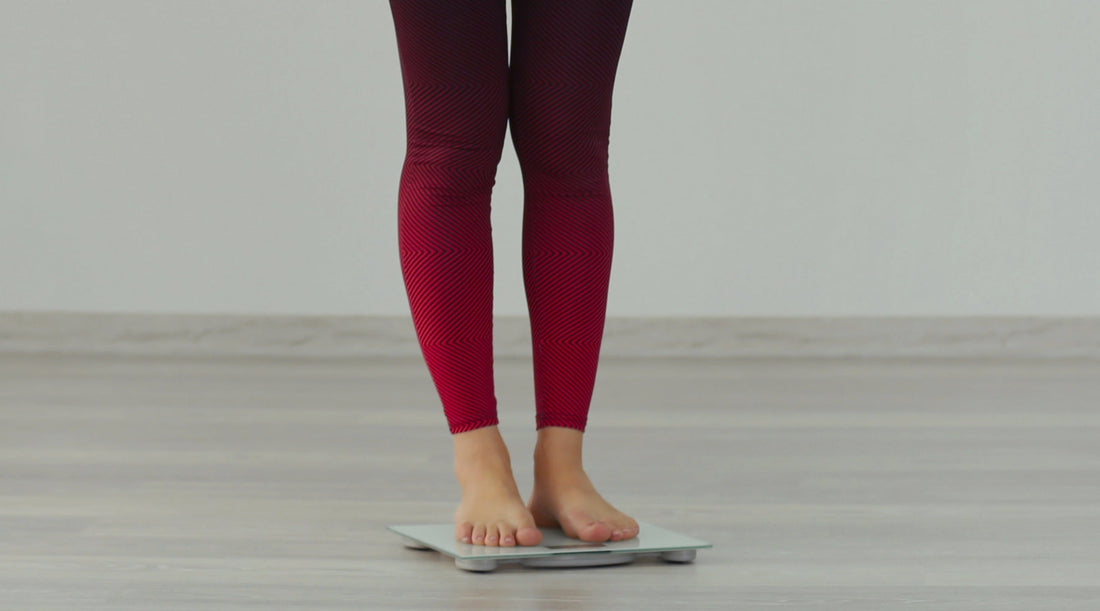 person weighing themselves on a scale